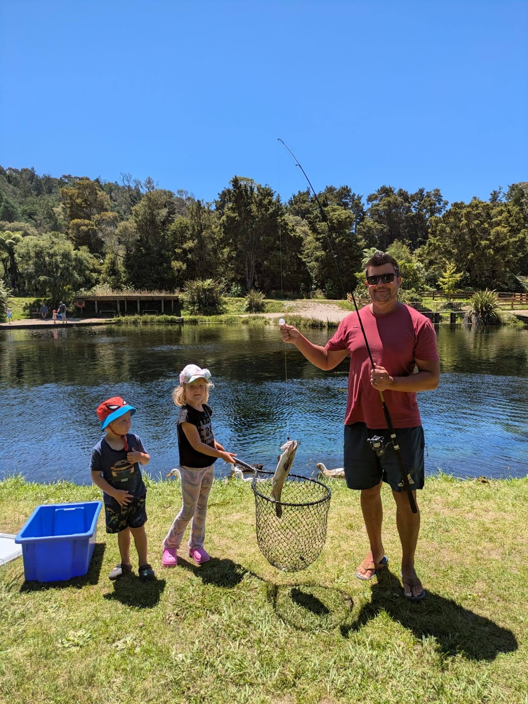 Denis fishing outdoors with two children
