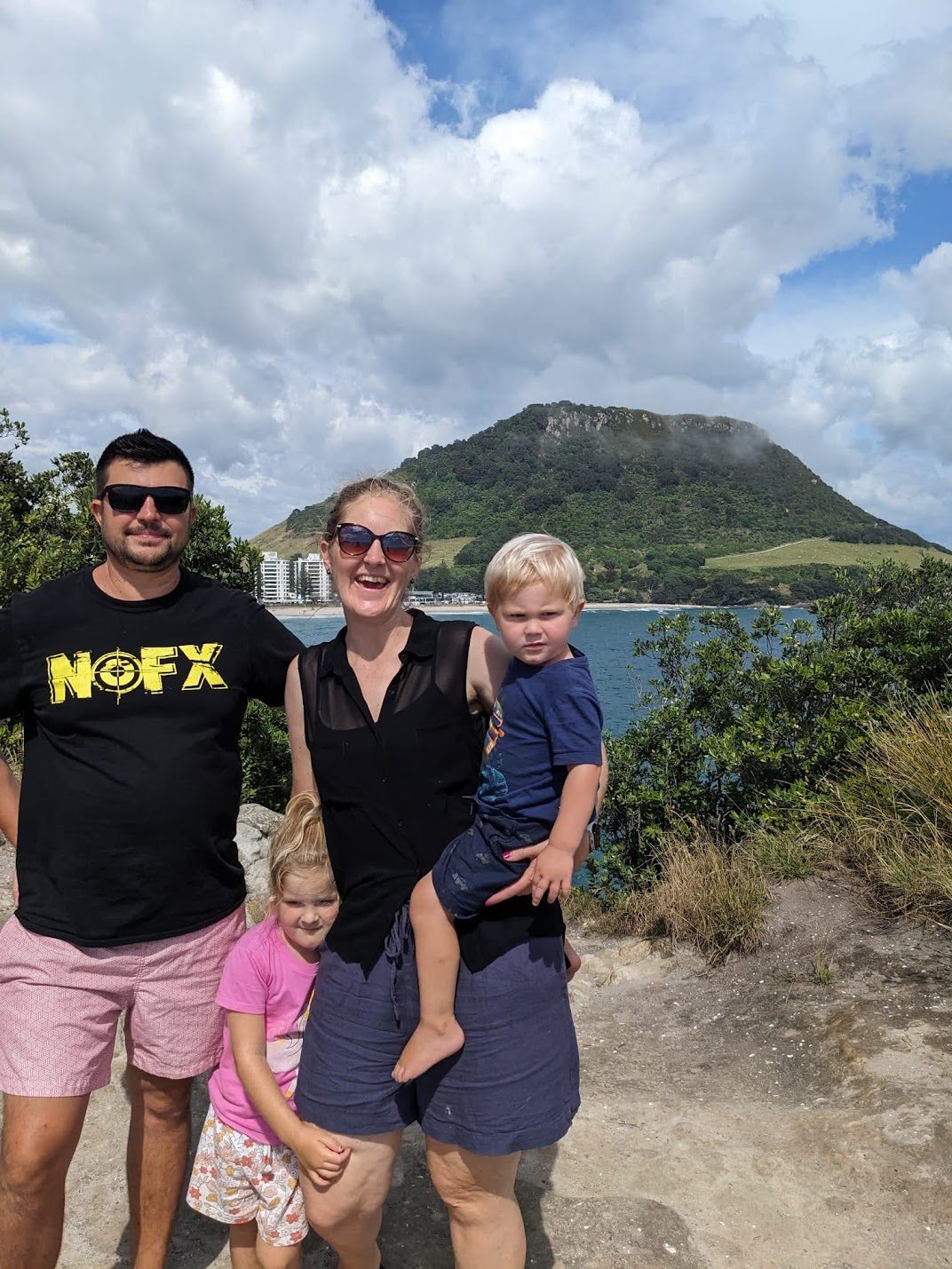 Denis with his family outdoors by the coast